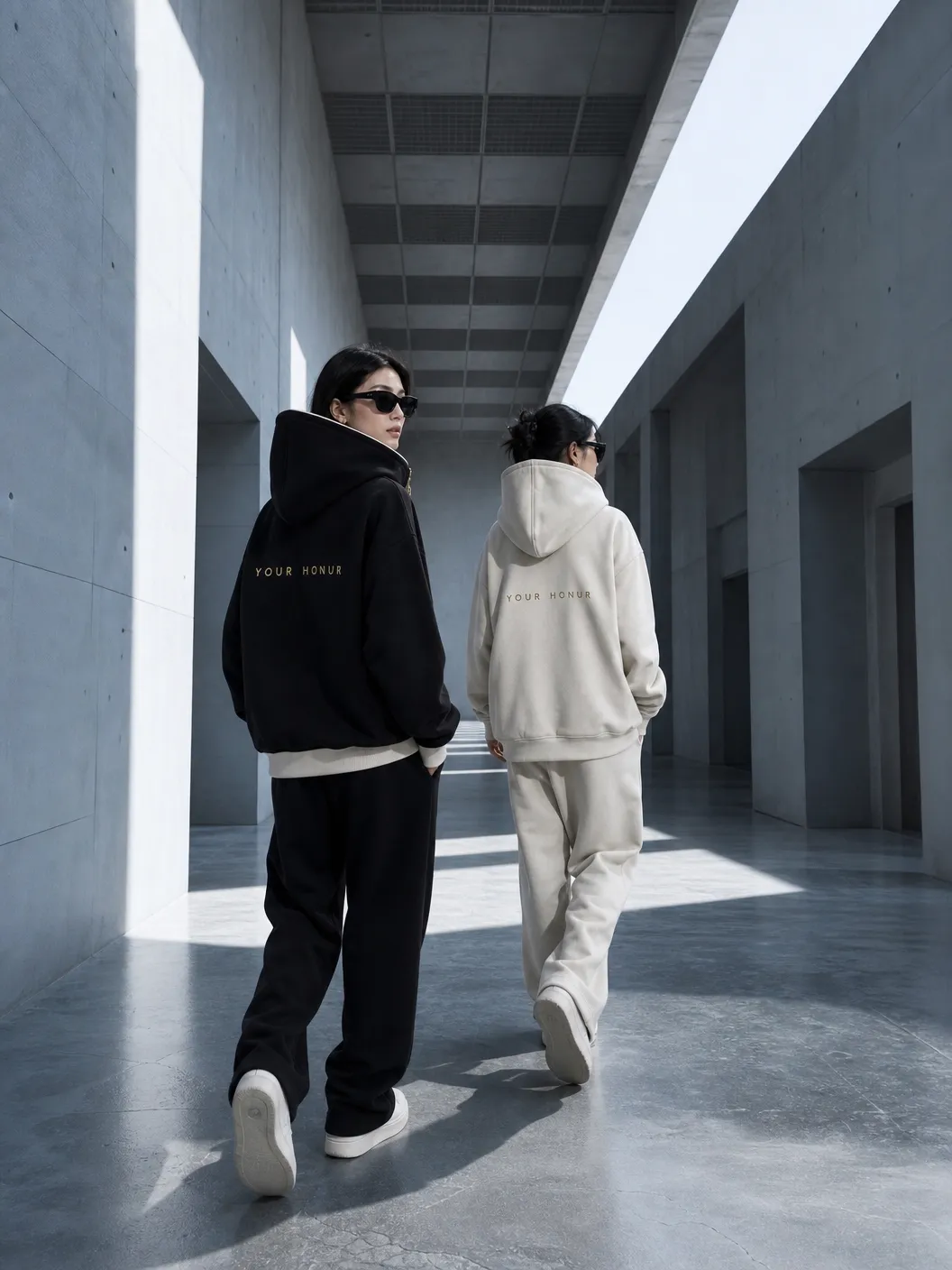 Reversible hoodie editorial — concrete corridor, gold wordmark on back · Your Honur